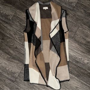 Camel , black and white sweater vest .